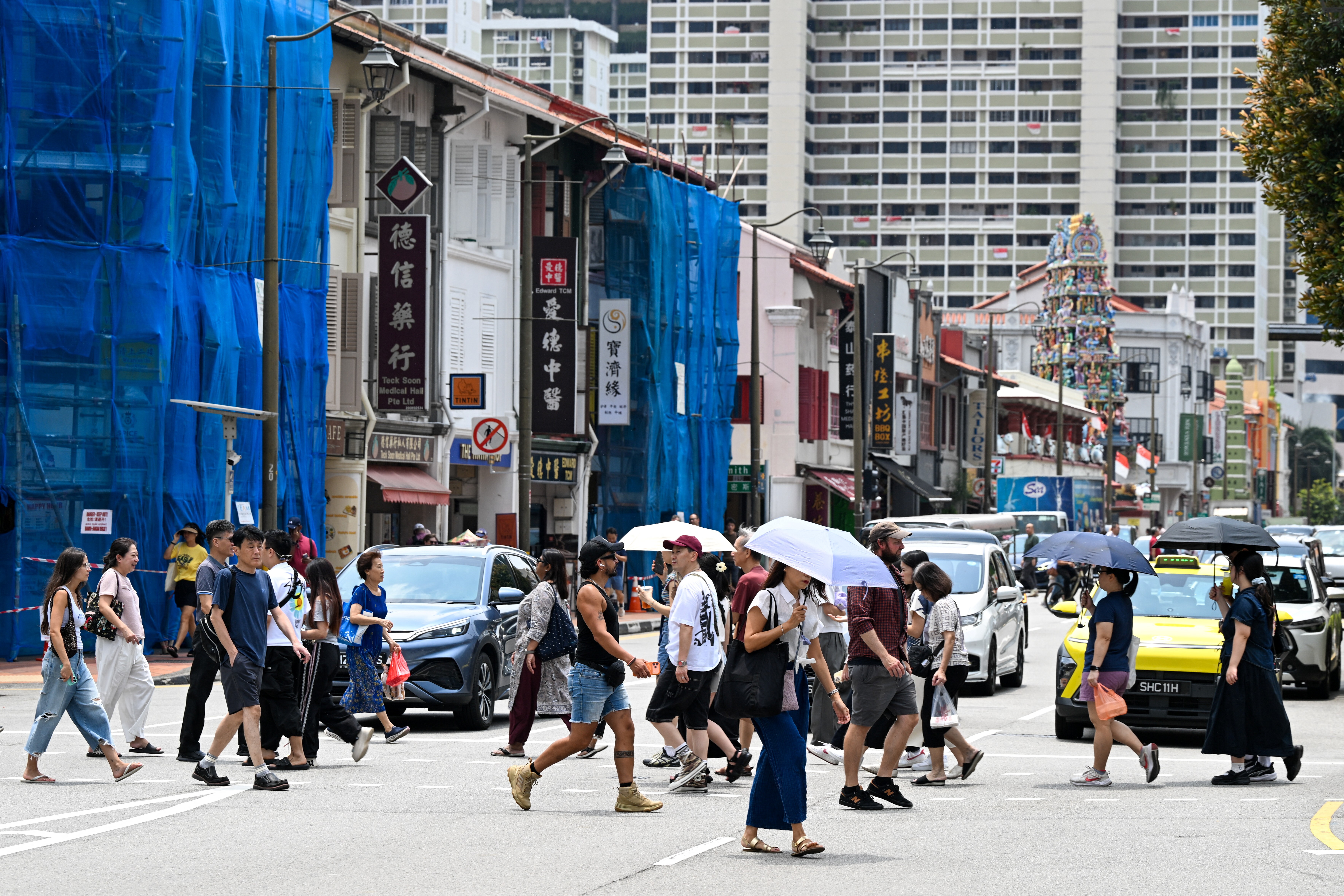 Pedestrians cross a road in Singapore